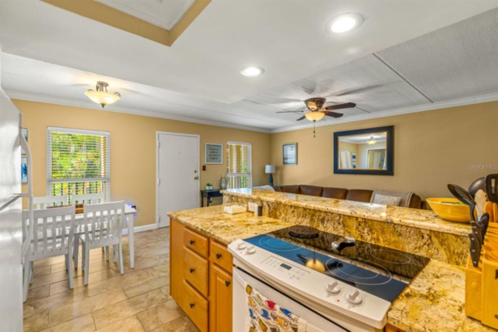 8911 Blind Pass Road, Unit 223 St. Pete Beach, FL 33706 - Photo 17 of 27 a view of a kitchen with kitchen island granite countertop a table and chairs
