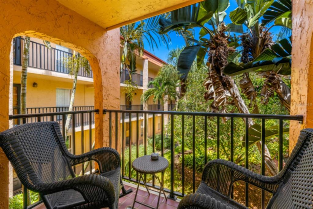 8911 Blind Pass Road, Unit 223 St. Pete Beach, FL 33706 - Photo 2 of 27 a balcony with table and chairs