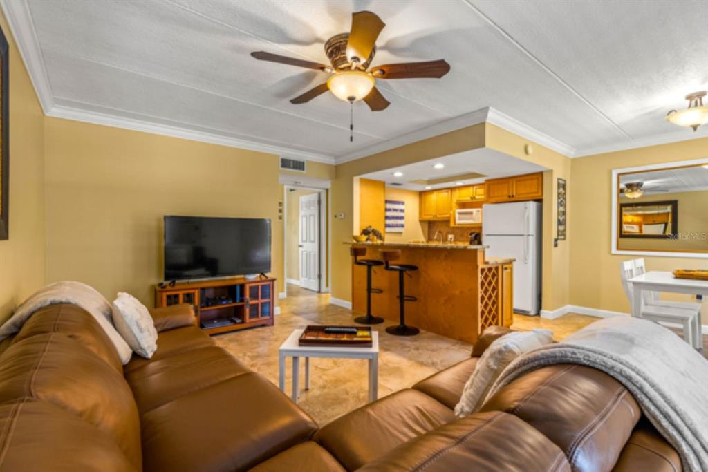 8911 Blind Pass Road, Unit 223 St. Pete Beach, FL 33706 - Photo 4 of 27 a living room with furniture and a flat screen tv
