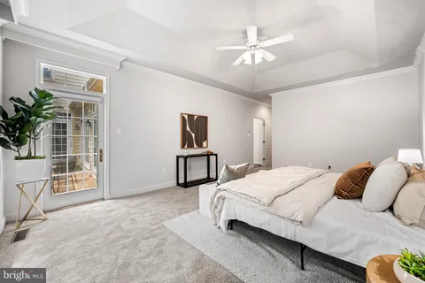 a bedroom with a bed gym equipment and view of living room