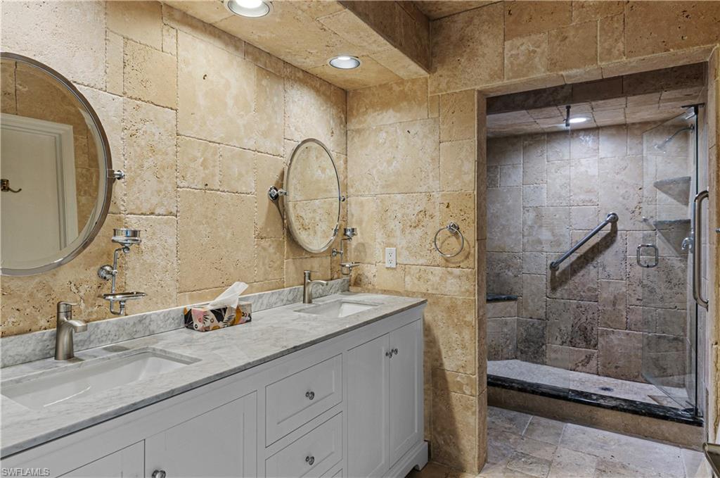 802 10th Avenue South, Unit 802 Naples, FL 34102 - Photo 12 of 13 a bathroom with a double vanity sink mirror and shower