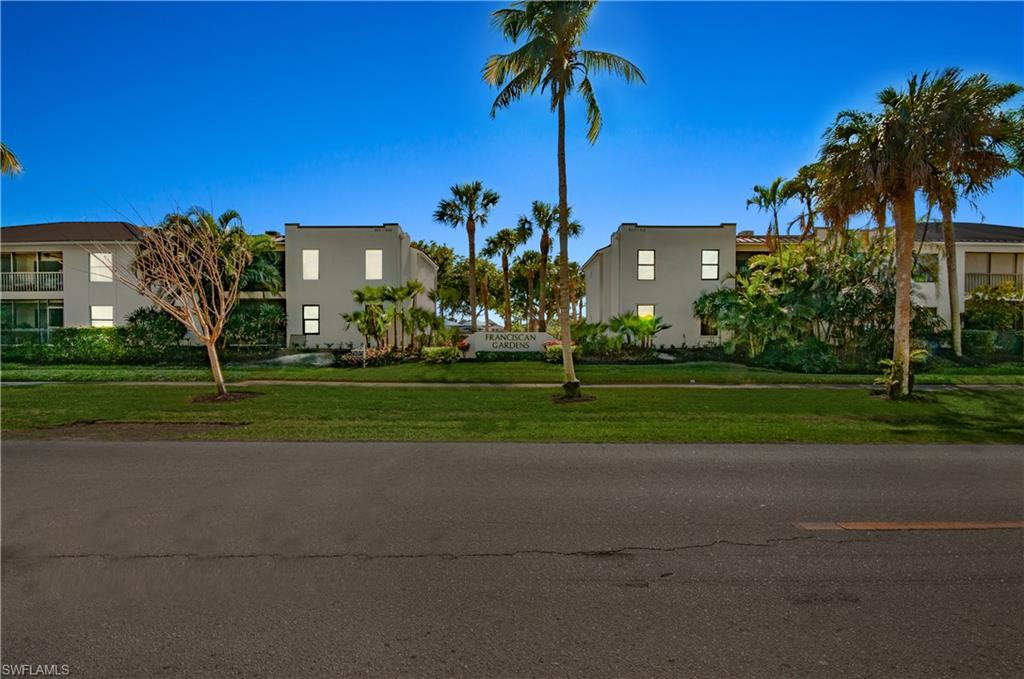 802 10th Avenue South, Unit 802 Naples, FL 34102 - Photo 13 of 13 a view of a tall white house with a big yard and palm trees