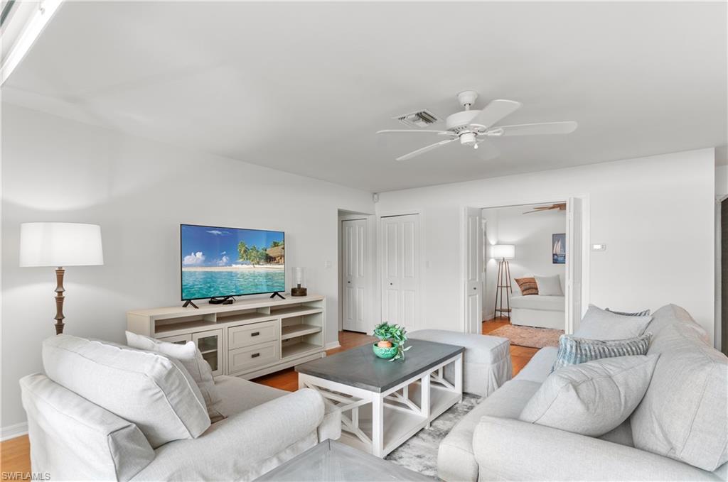 802 10th Avenue South, Unit 802 Naples, FL 34102 - Photo 6 of 13 a living room with furniture and a flat screen tv