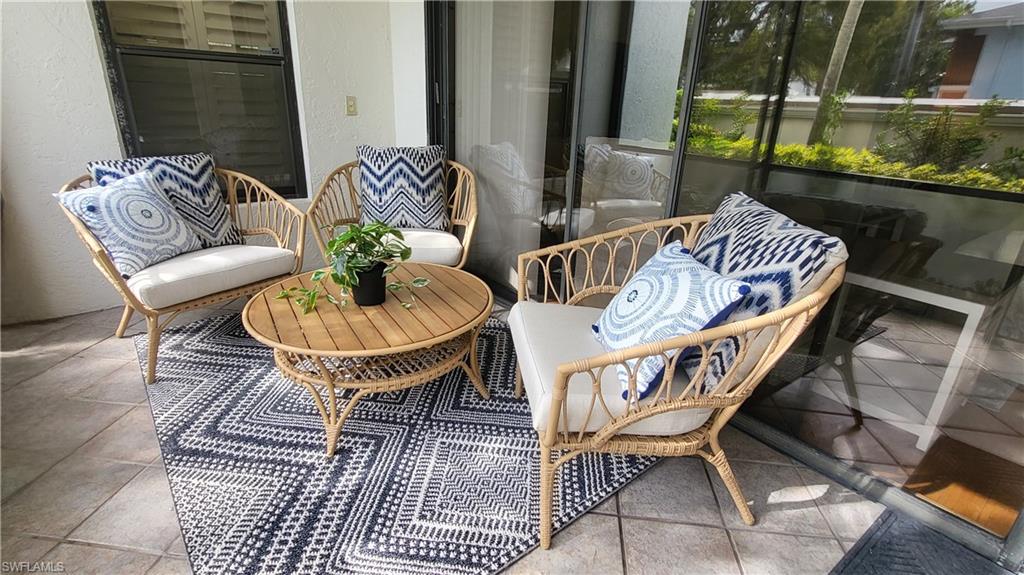 802 10th Avenue South, Unit 802 Naples, FL 34102 - Photo 7 of 13 a balcony with table and chairs