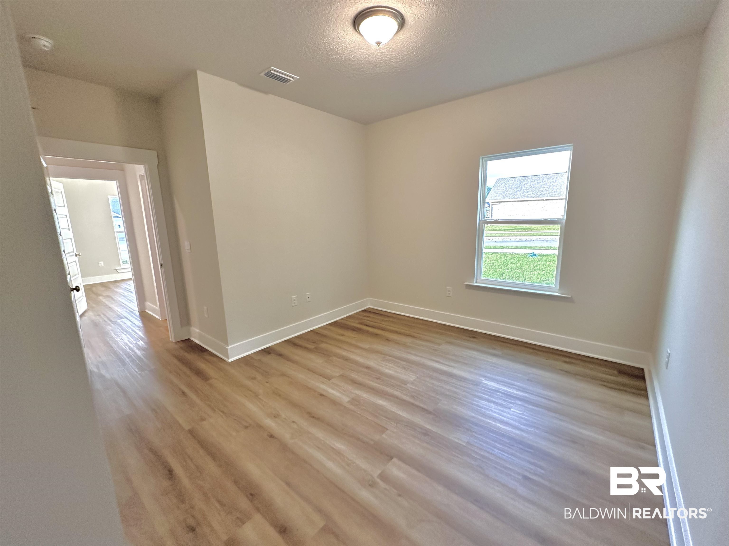 342 Barndling Street Fairhope, AL 36532 - Photo 23 of 50 Spare room with light wood-type flooring and a textured ceiling