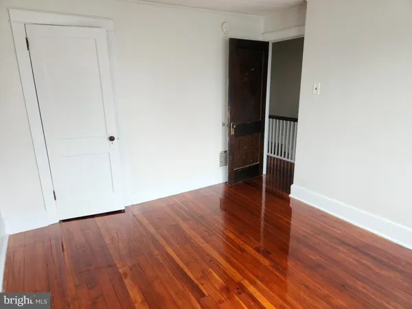 an empty room with wooden floor and closet