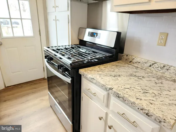 a view of kitchen island with sink stove and refrigerator