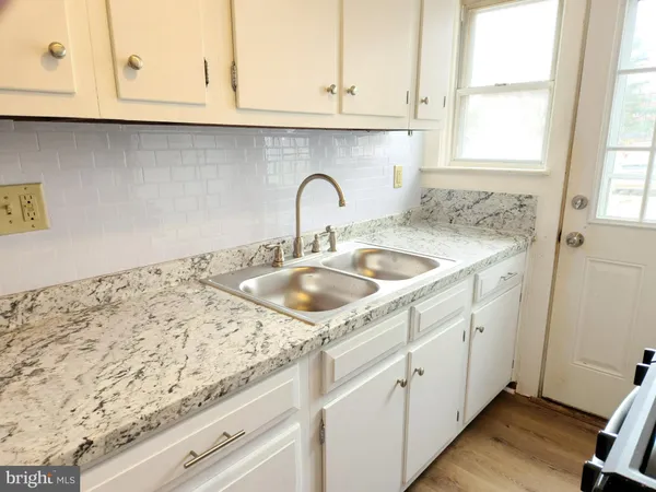 a sink with white cabinets