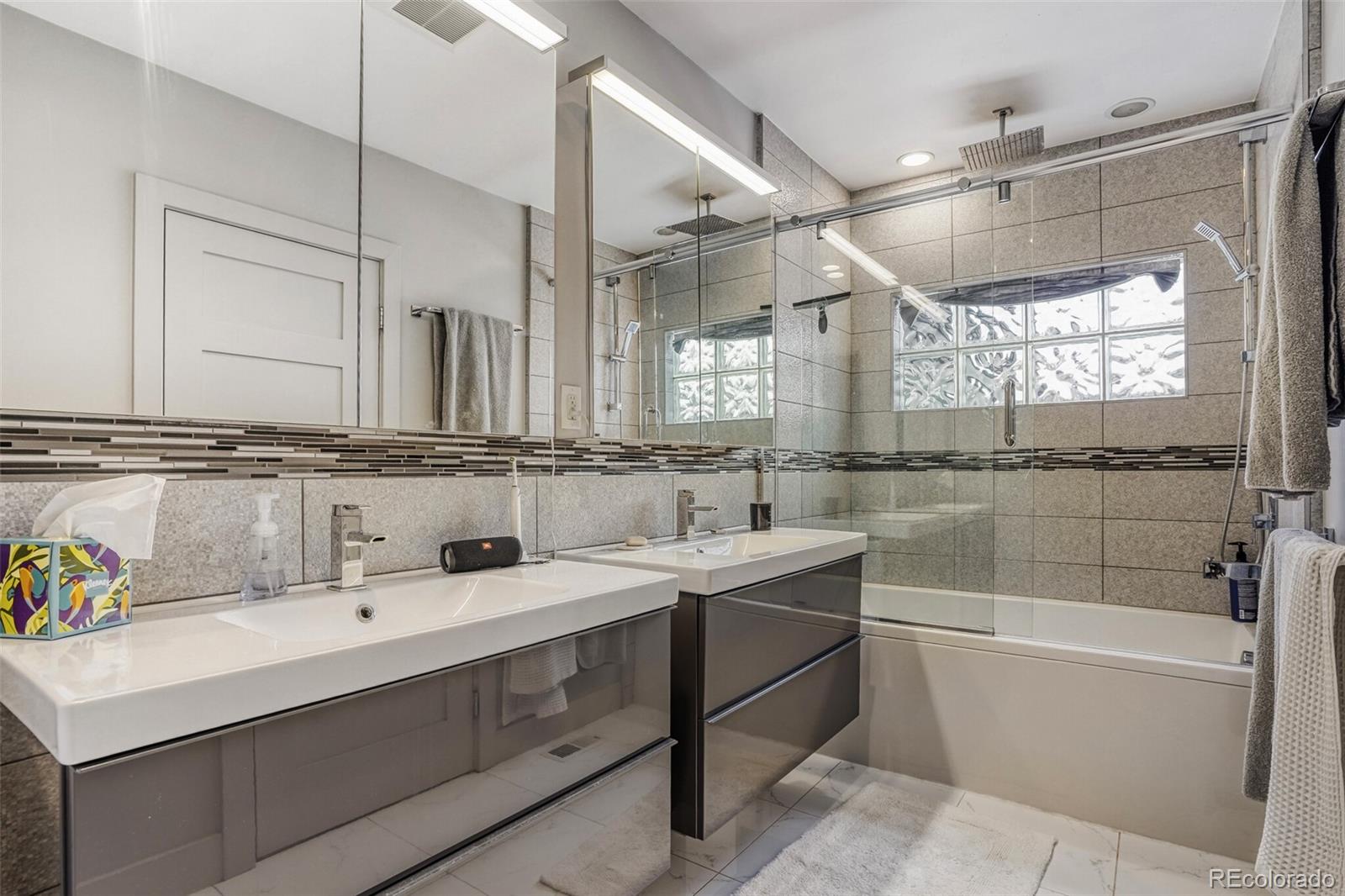 1322 South Pearl Street Denver, CO 80210 - Photo 20 of 39 a bathroom with a bathtub shower sink vanity and mirror