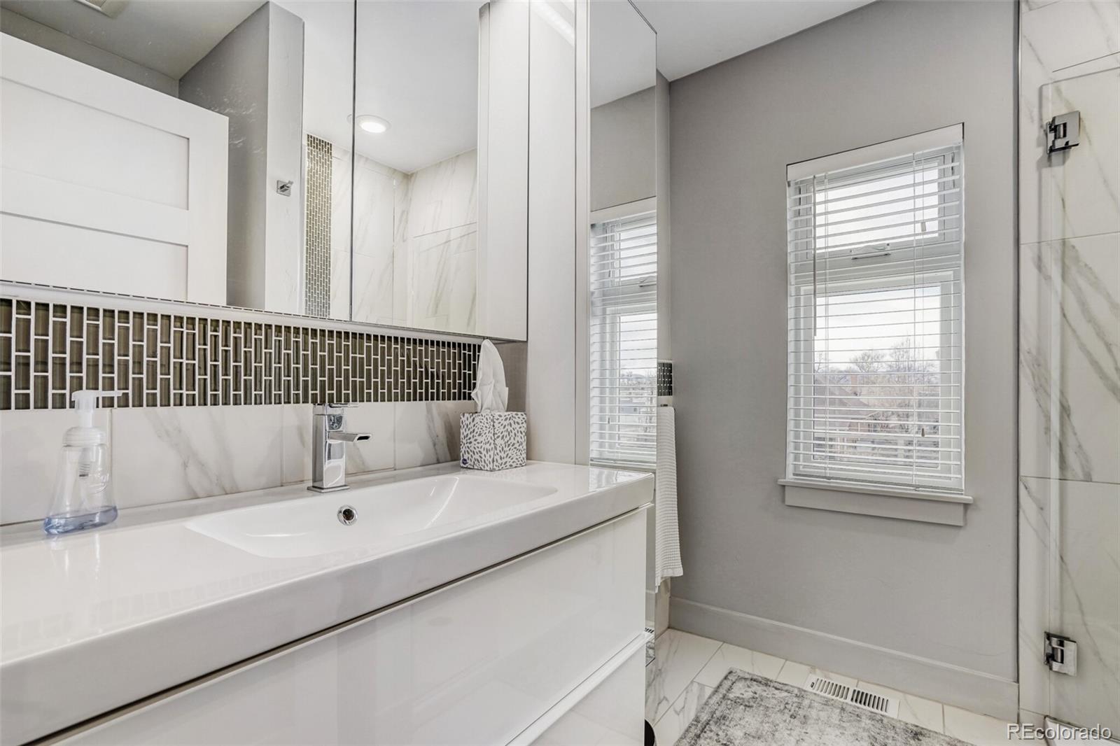 1322 South Pearl Street Denver, CO 80210 - Photo 25 of 39 a bathroom with a tub sink and mirror