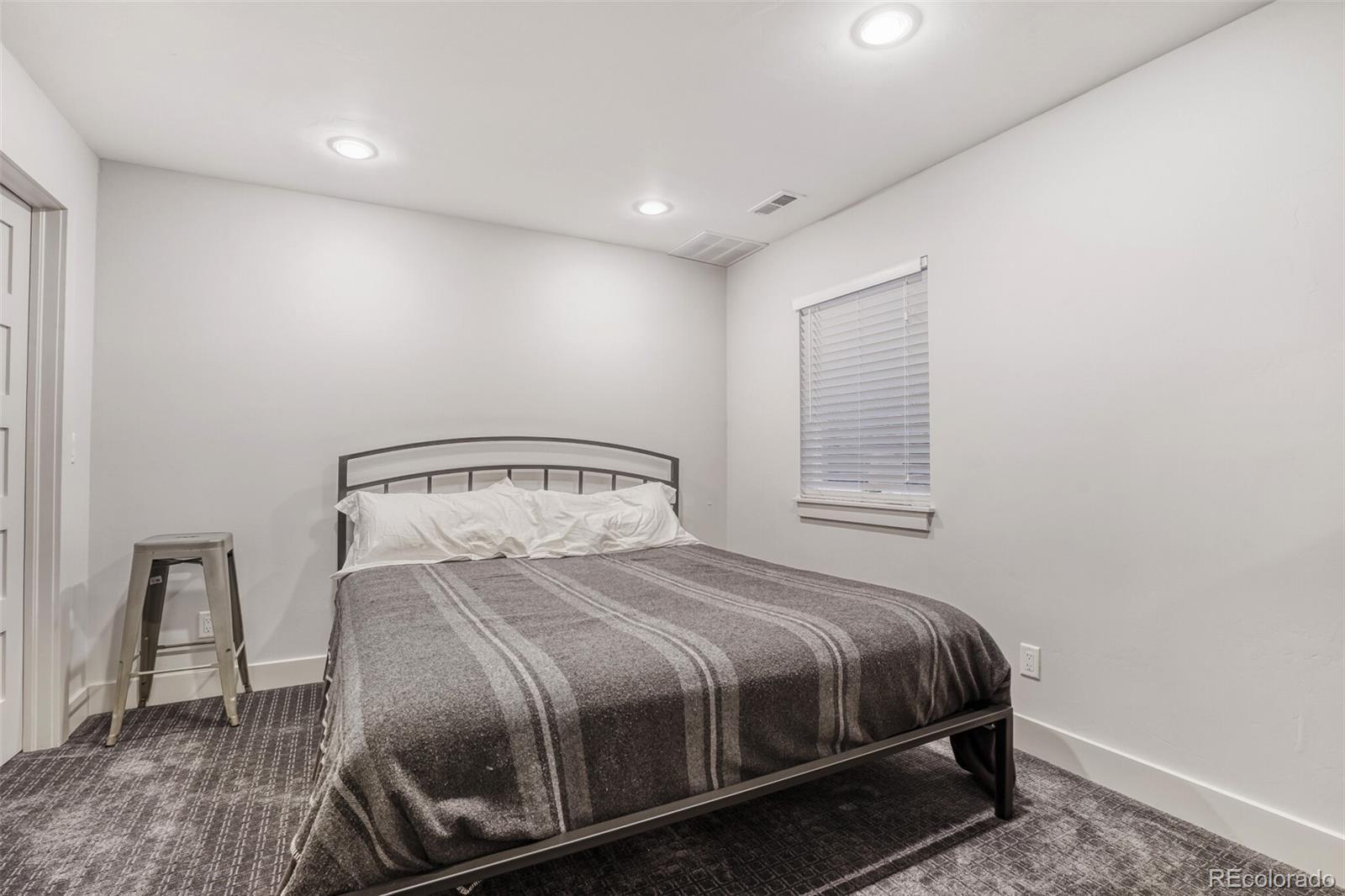 1322 South Pearl Street Denver, CO 80210 - Photo 30 of 39 a large bed sitting in a bedroom next to a window