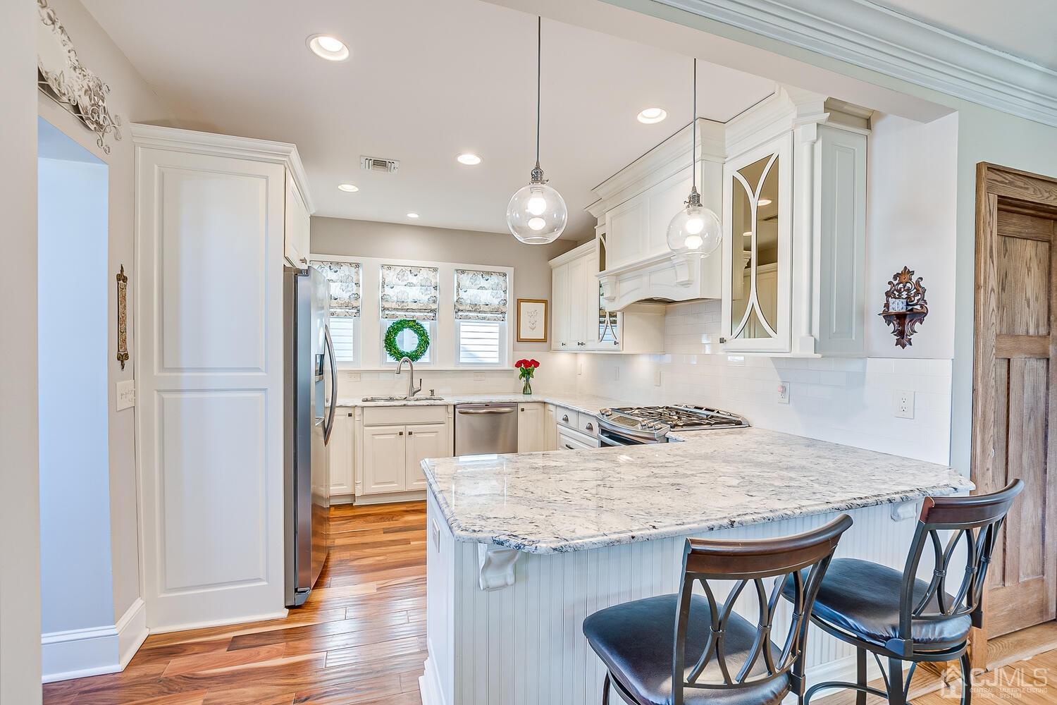 29 Jefferson Avenue Edison, NJ 08837 - Photo 14 of 36 a kitchen with kitchen island a dining table chairs sink and cabinets