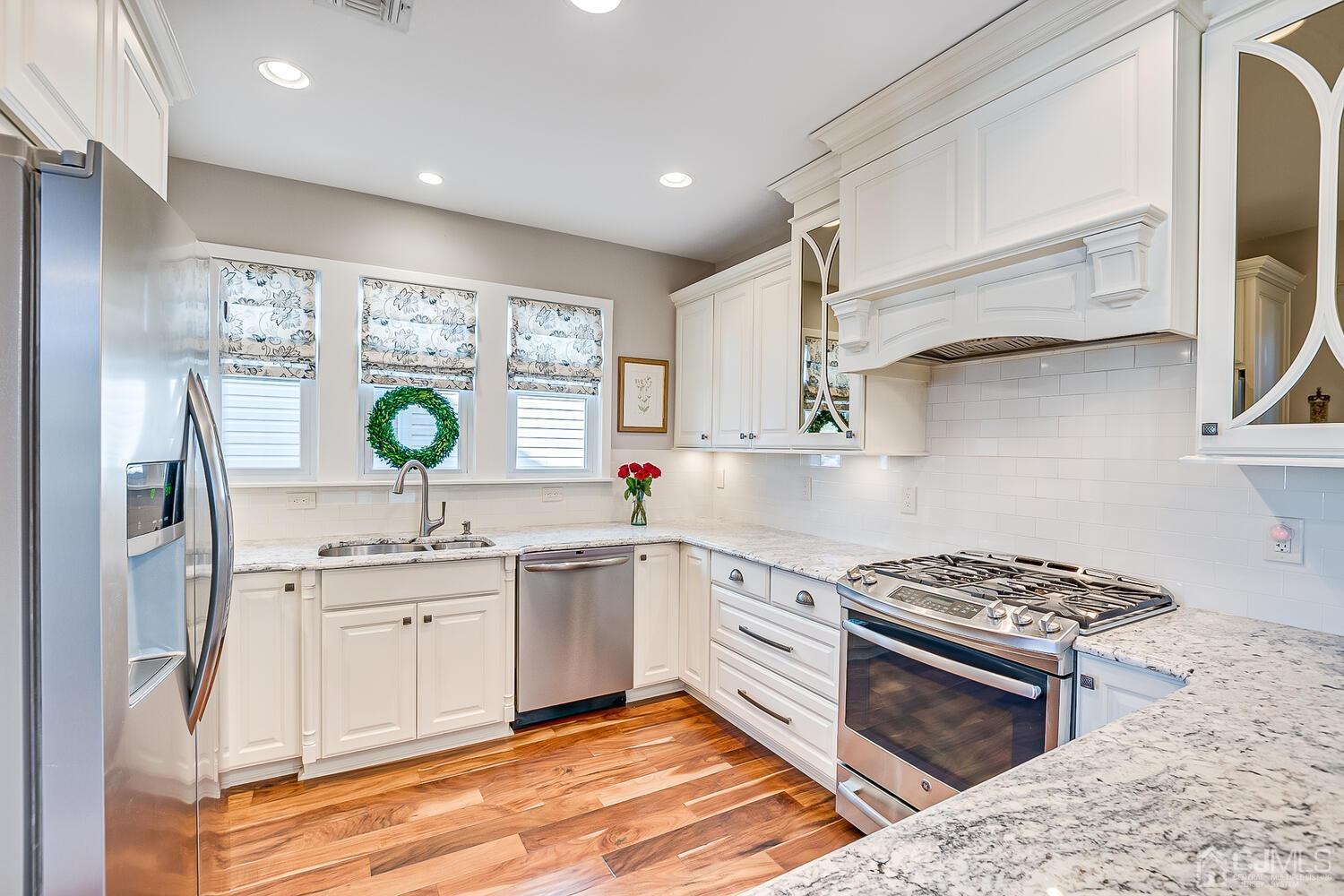 29 Jefferson Avenue Edison, NJ 08837 - Photo 16 of 36 a kitchen with stainless steel appliances a sink a stove a refrigerator cabinets and a window