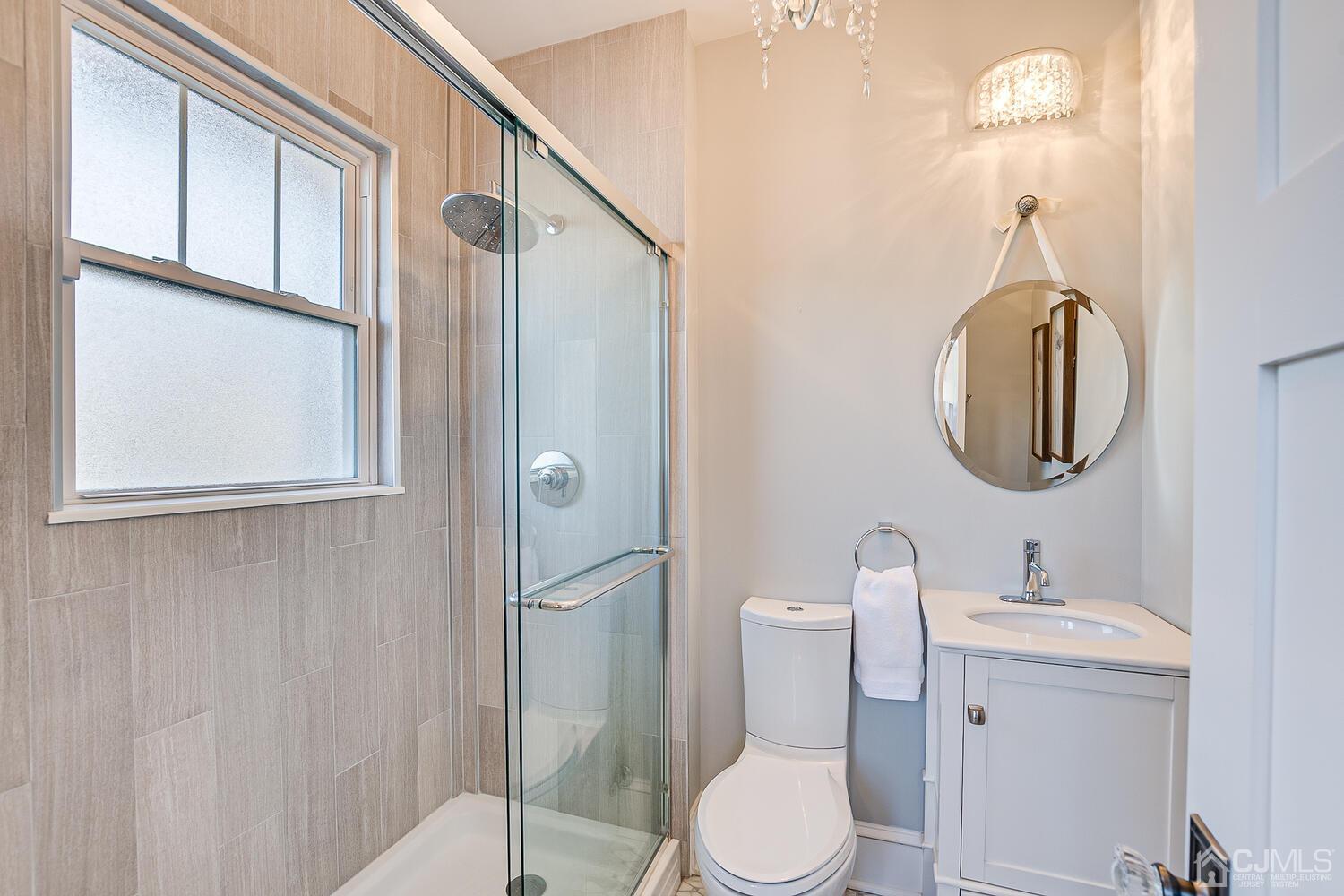 29 Jefferson Avenue Edison, NJ 08837 - Photo 20 of 36 a bathroom with a toilet a sink a mirror and shower