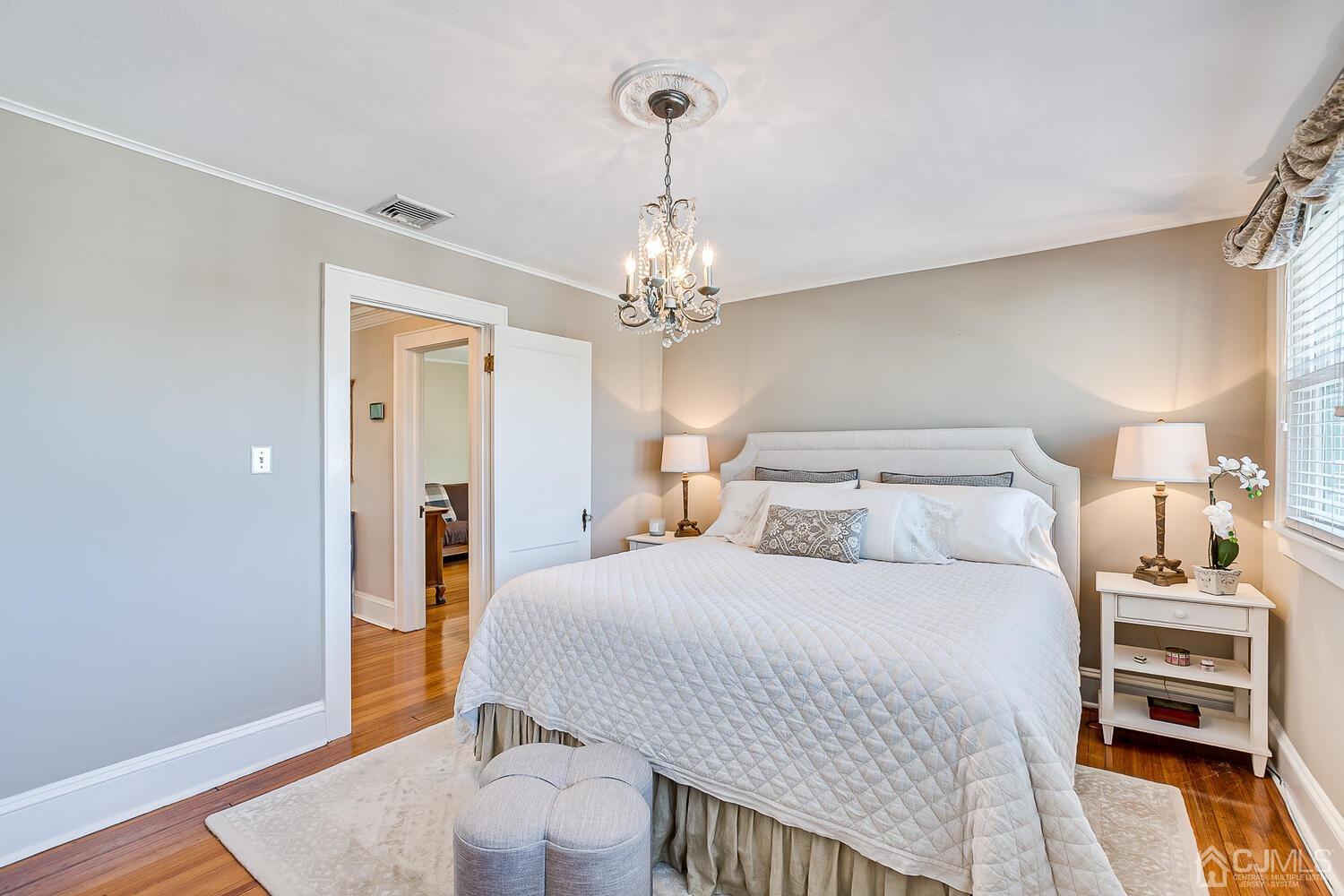 29 Jefferson Avenue Edison, NJ 08837 - Photo 23 of 36 a bedroom with a bed and a chandelier