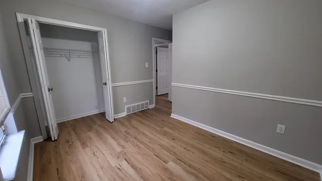 an empty room with wooden floor and entrance