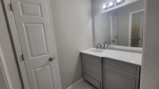 a bathroom with a sink vanity and a mirror