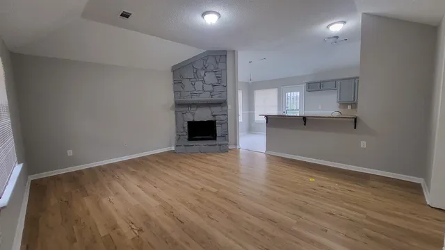 an empty room with wooden floor and entrance