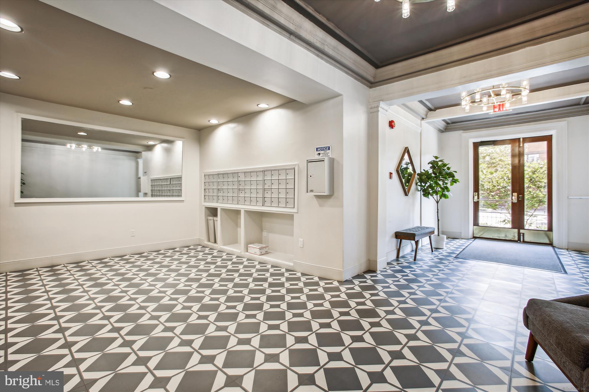 1669 Columbia Road Northwest, Unit 204 Washington, DC 20009 - Photo 6 of 42 a living room with a black white checkered floor with a gaming machine and dining chair