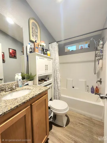 a bathroom with a granite countertop sink mirror vanity and toilet