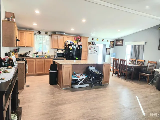 a kitchen with stainless steel appliances kitchen island granite countertop a sink and cabinets