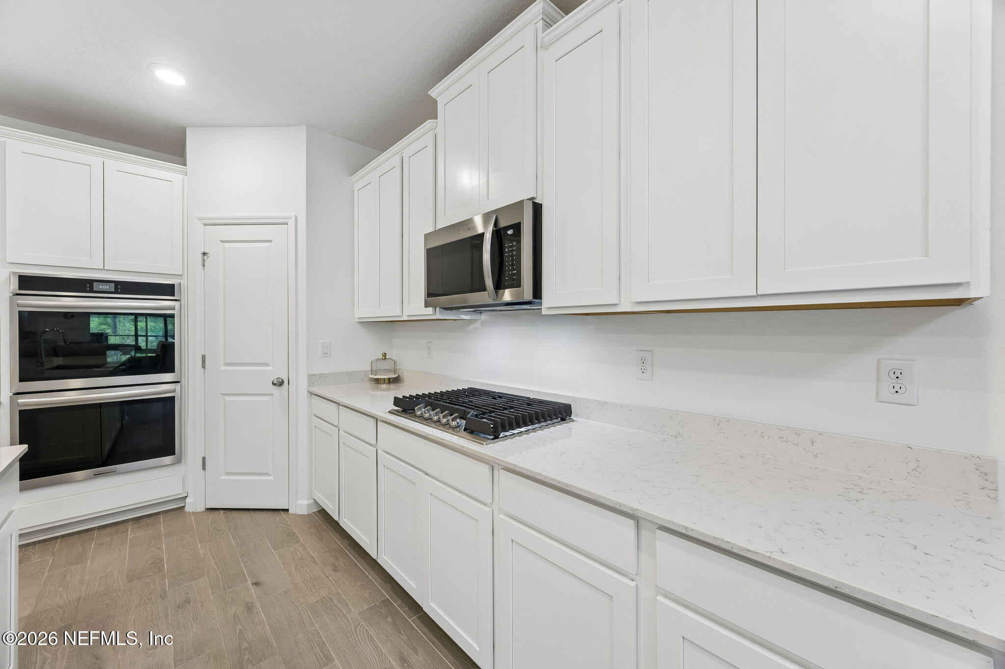 75626 Pondside Lane Yulee, FL 32097 - Photo 16 of 95 a kitchen with stainless steel appliances granite countertop white cabinets and a stove a oven with white countertops