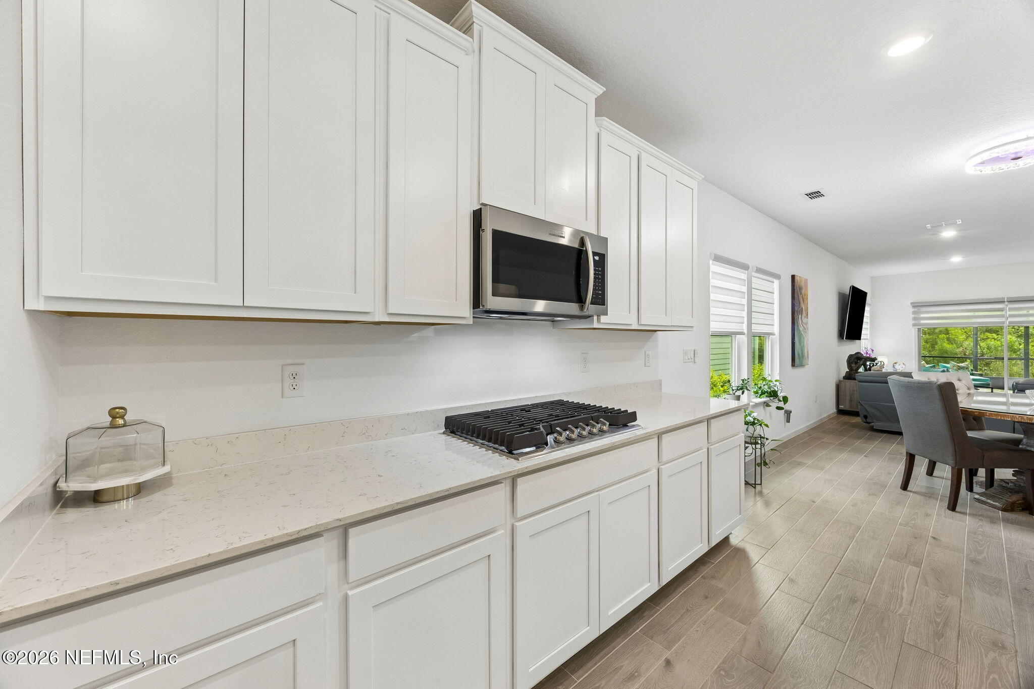 75626 Pondside Lane Yulee, FL 32097 - Photo 17 of 95 a kitchen with stainless steel appliances granite countertop a stove a sink dishwasher and a microwave with wooden floor