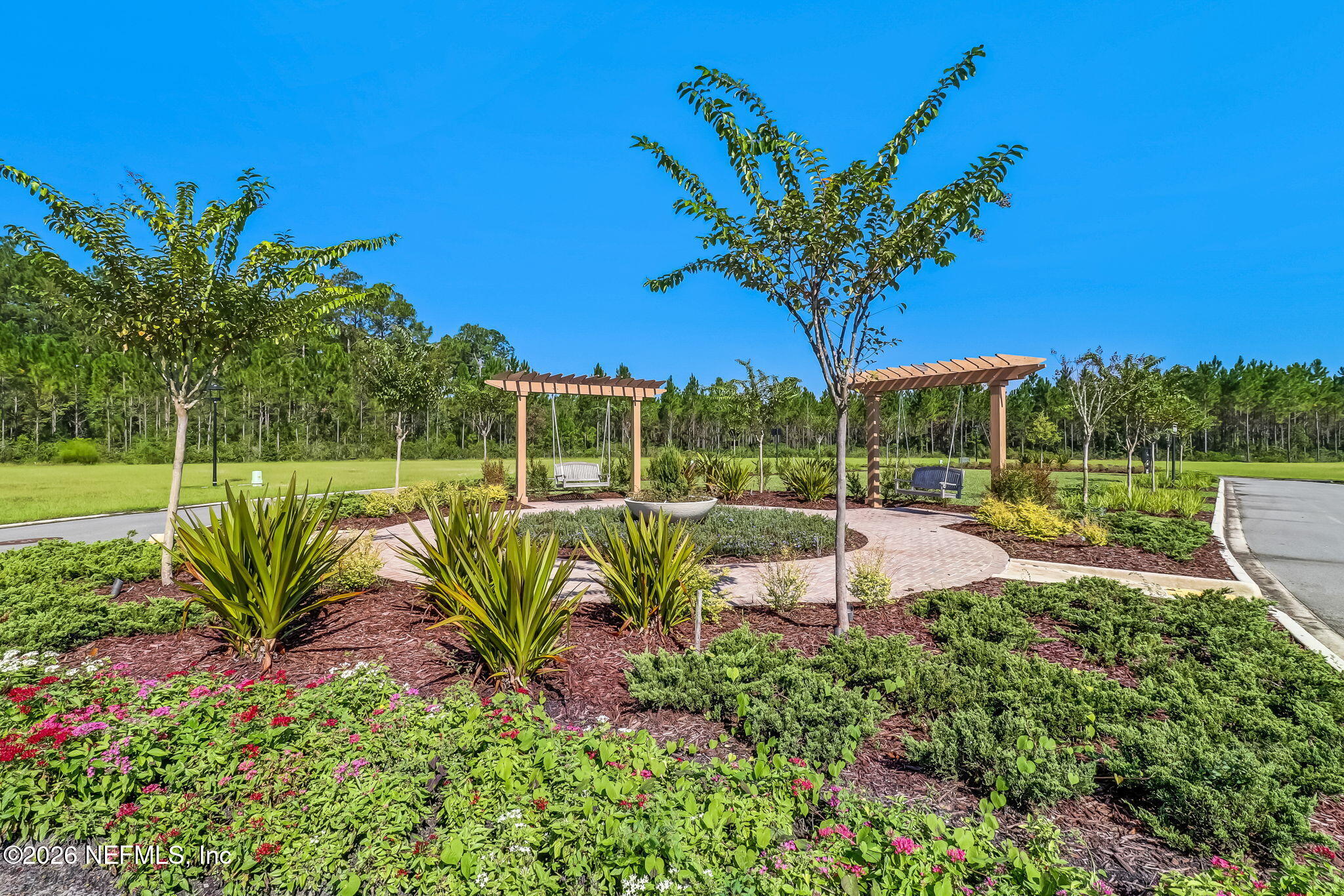 75626 Pondside Lane Yulee, FL 32097 - Photo 60 of 95 a view of a garden with a bench