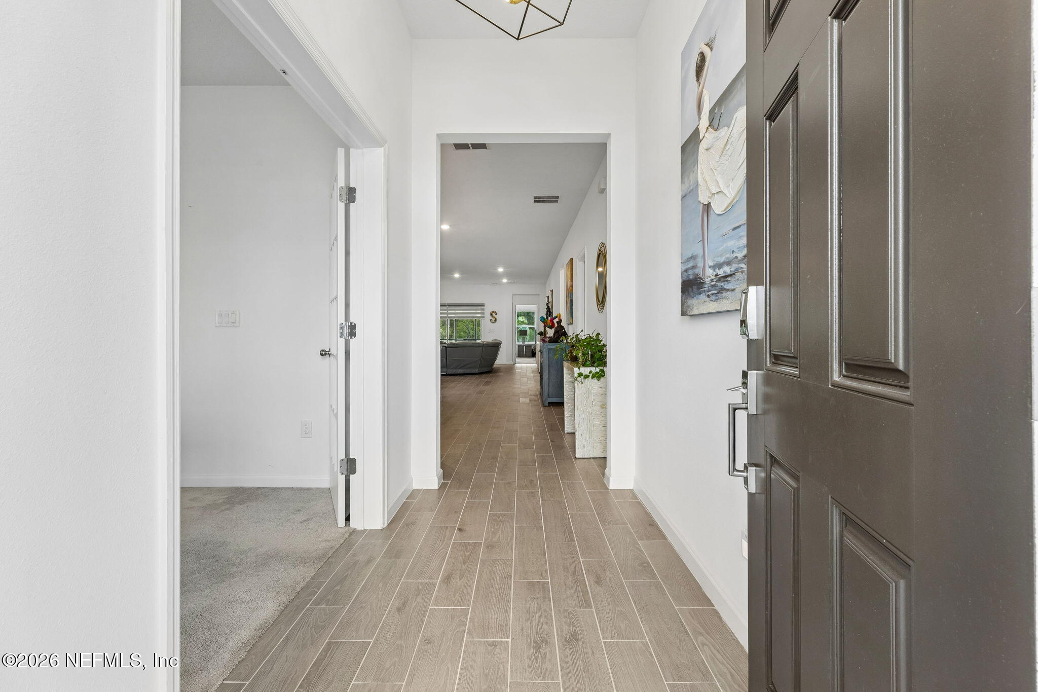 75626 Pondside Lane Yulee, FL 32097 - Photo 8 of 95 a view of a hallway with wooden floor and a living room