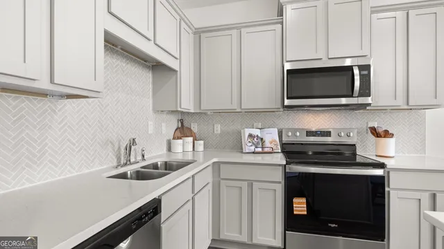 a kitchen with white cabinets and black appliances