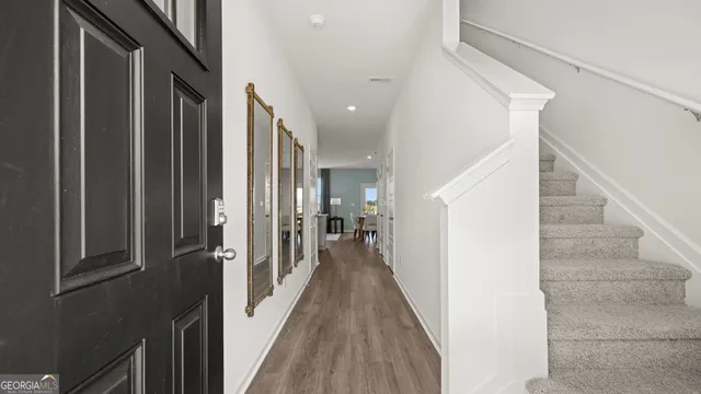 a view of a hallway with wooden floor and staircase