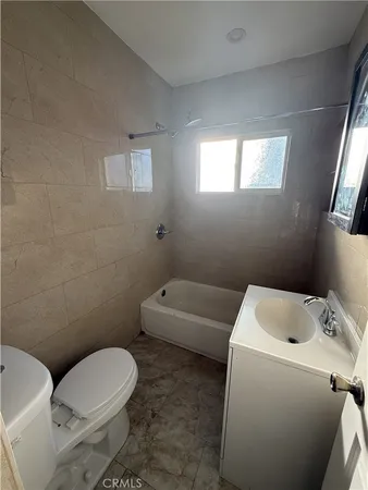 a white toilet sitting next to a bathroom sink and vanity