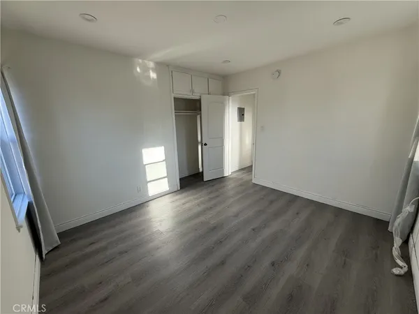 a view of empty room with wooden floor and window