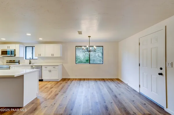a kitchen with wooden floors and white cabinets