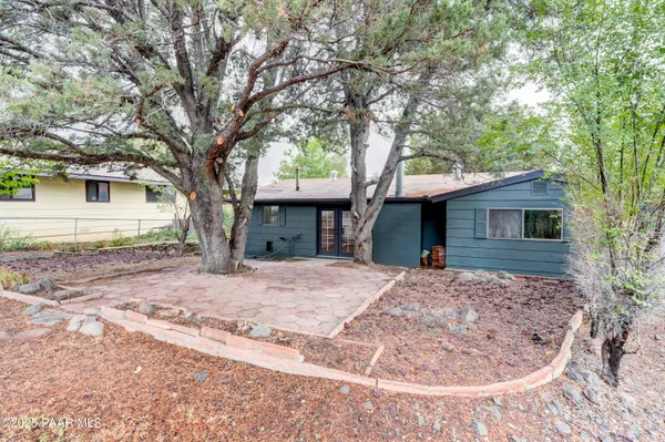 a tree in front of a white house