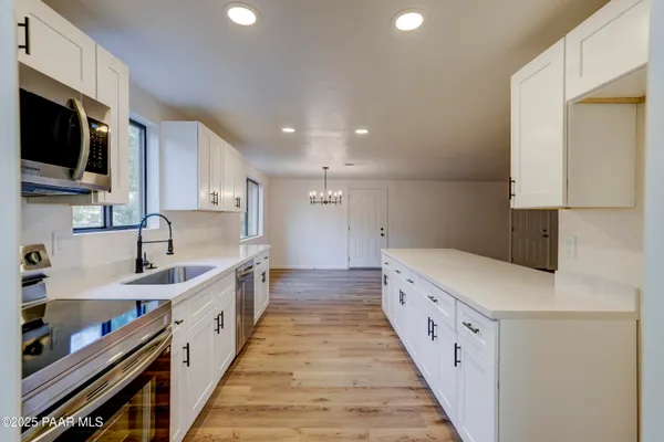 a large kitchen with stainless steel appliances sink a microwave and cabinets