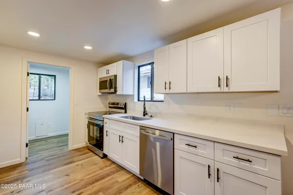 a kitchen with a sink dishwasher stove and cabinets