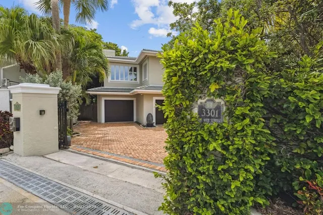 a view of a white house with a yard and potted plants