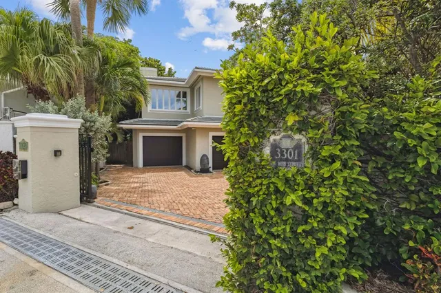 a view of a white house with a yard and potted plants