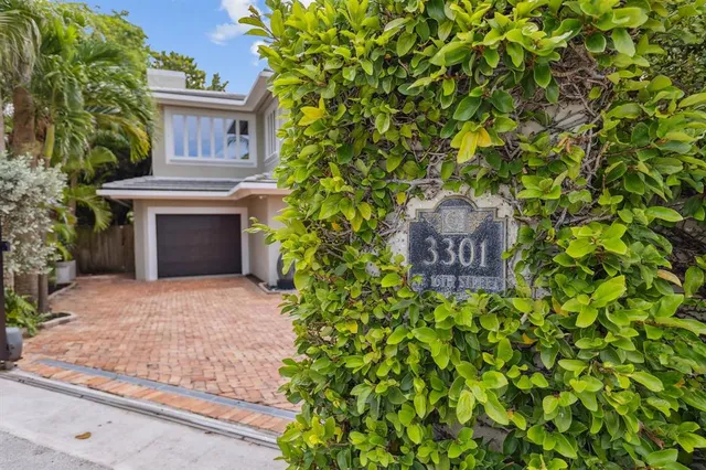 a front view of a house with a yard and a fountain