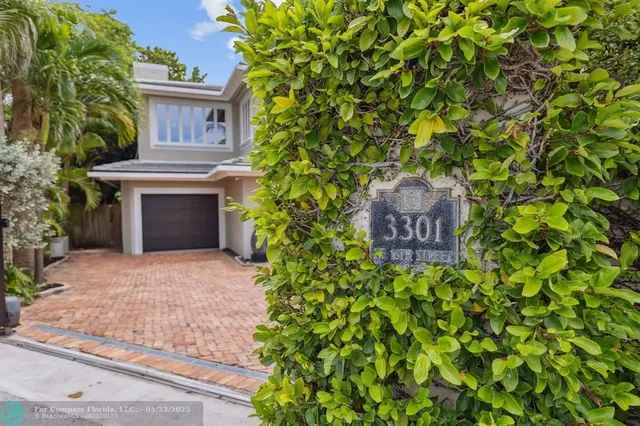 a front view of a house with a yard and a fountain