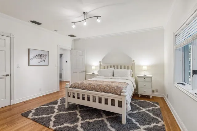 a large bedroom with a bed and wooden floor