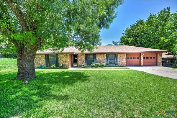 a front view of a house with yard patio and green space