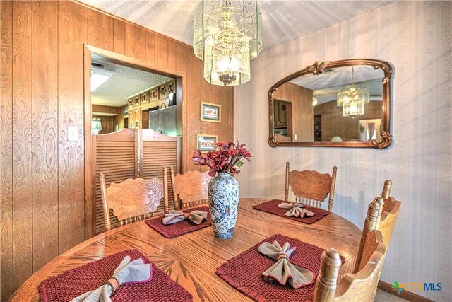 a living room with furniture a chandelier and a table