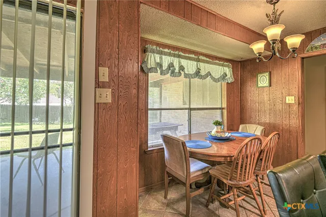 a view of a dining room with furniture wooden floor and chandelier