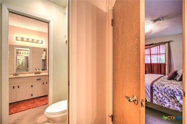 a bathroom with a toilet a sink and a window