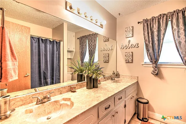 a bathroom with a double vanity sink and a mirror