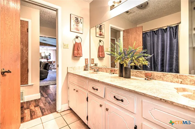 a bathroom with a granite countertop sink mirror and bathtub