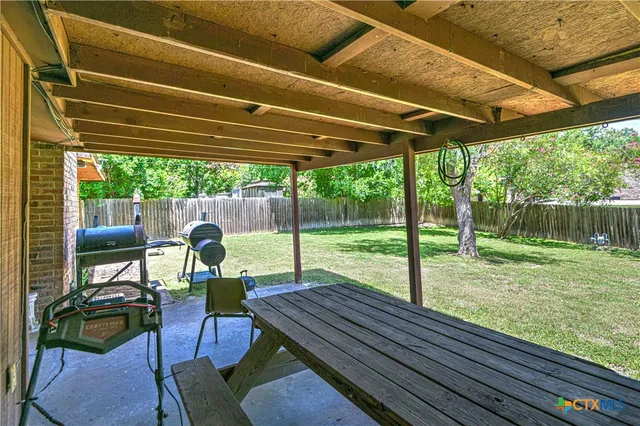 a view of a chairs and table in patio with a yard