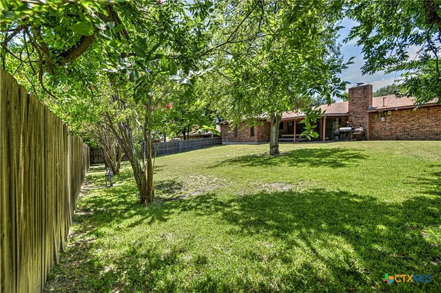 a house is sitting in middle of the green field